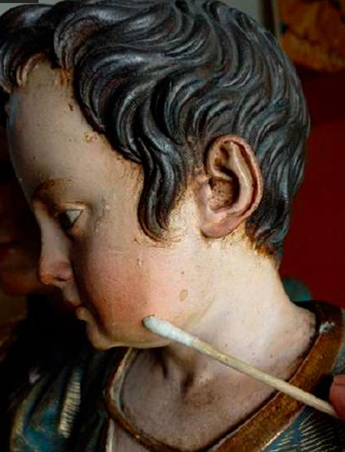 Trabajos de limpieza de suciedad y barnices oxidados en la encarnadura del Ni&ntilde;o.